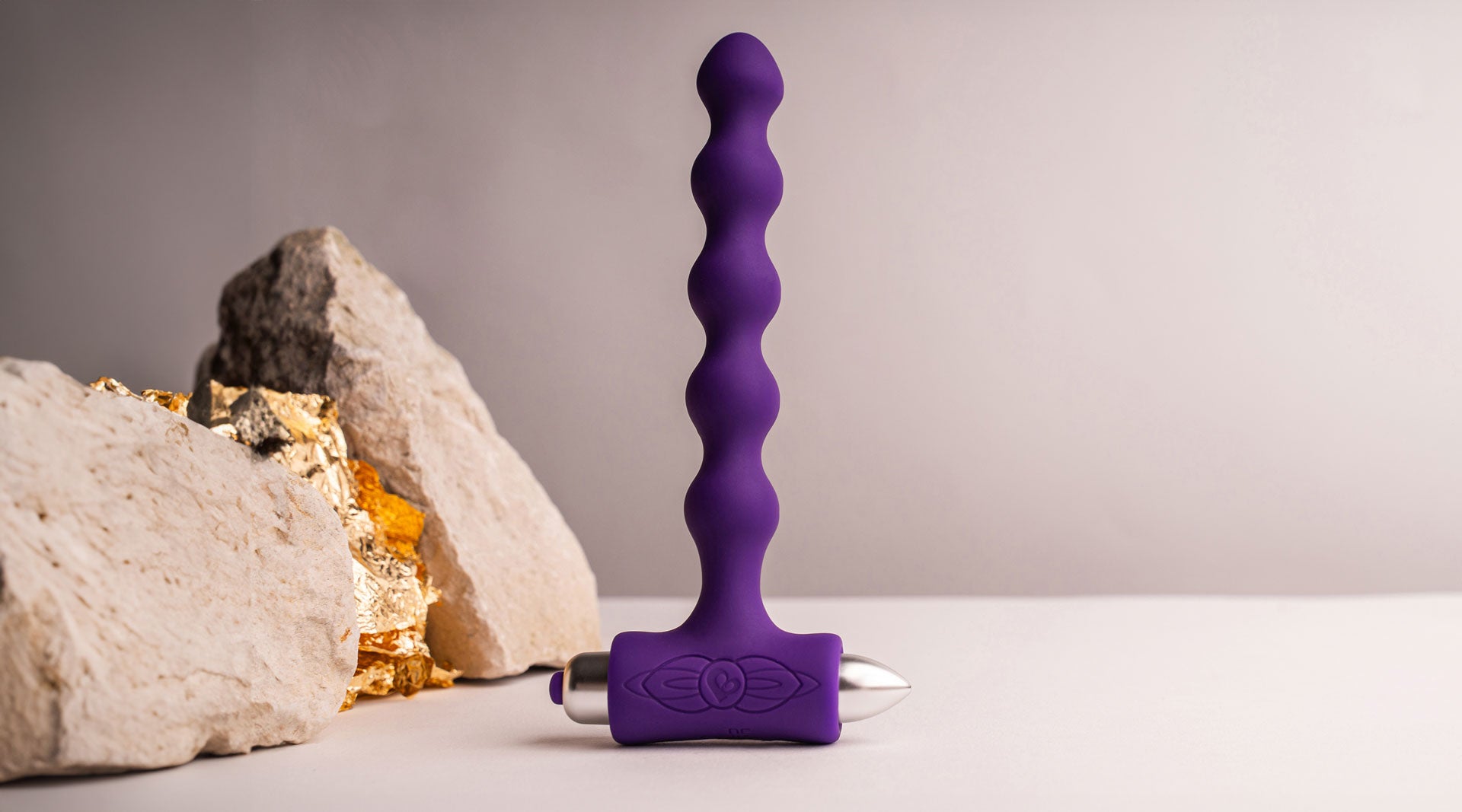 Beaded silicone butt plug in purple housing a removable bullet vibrator.