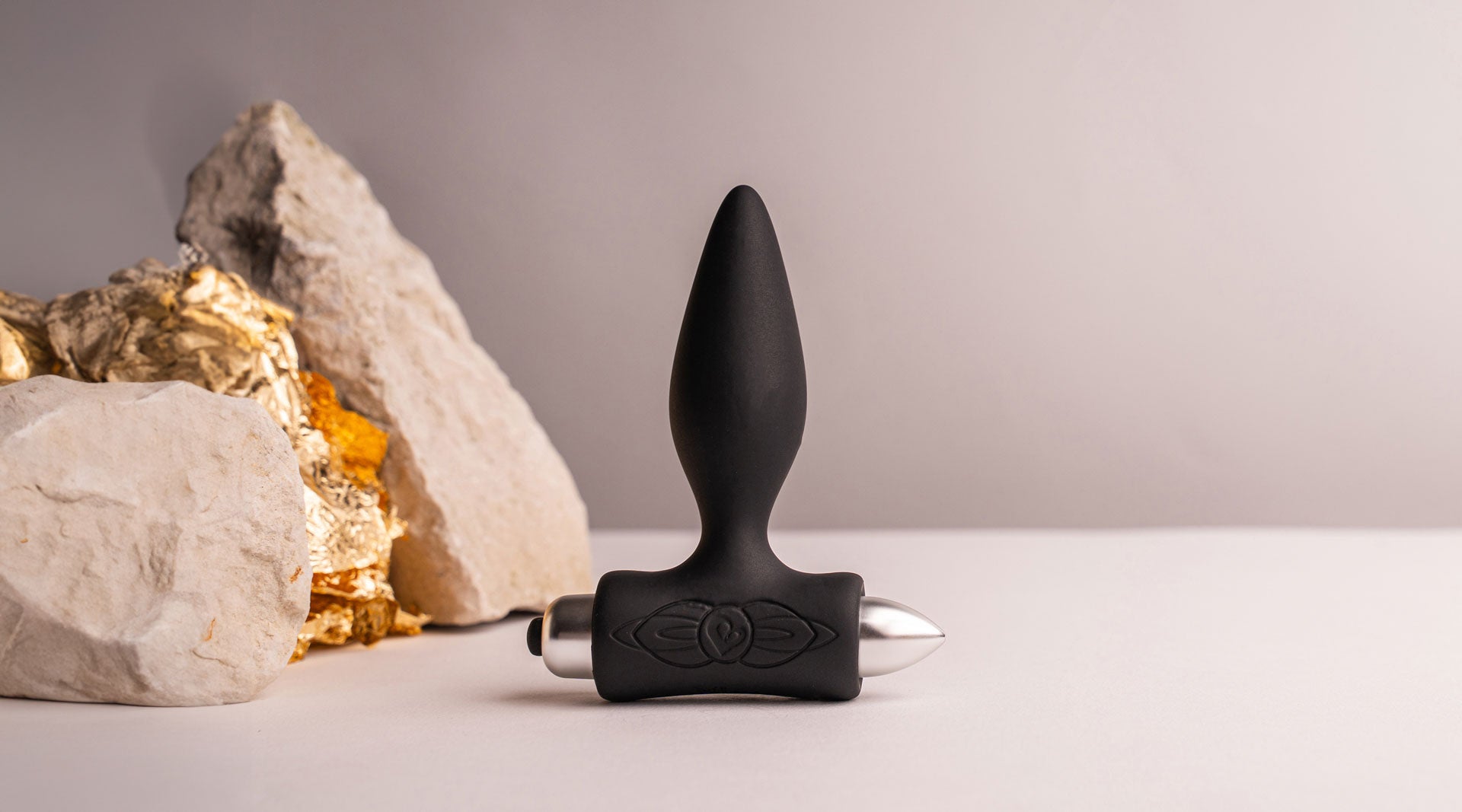 Black silicone tapered tip butt plug housing a removable bullet vibrator.