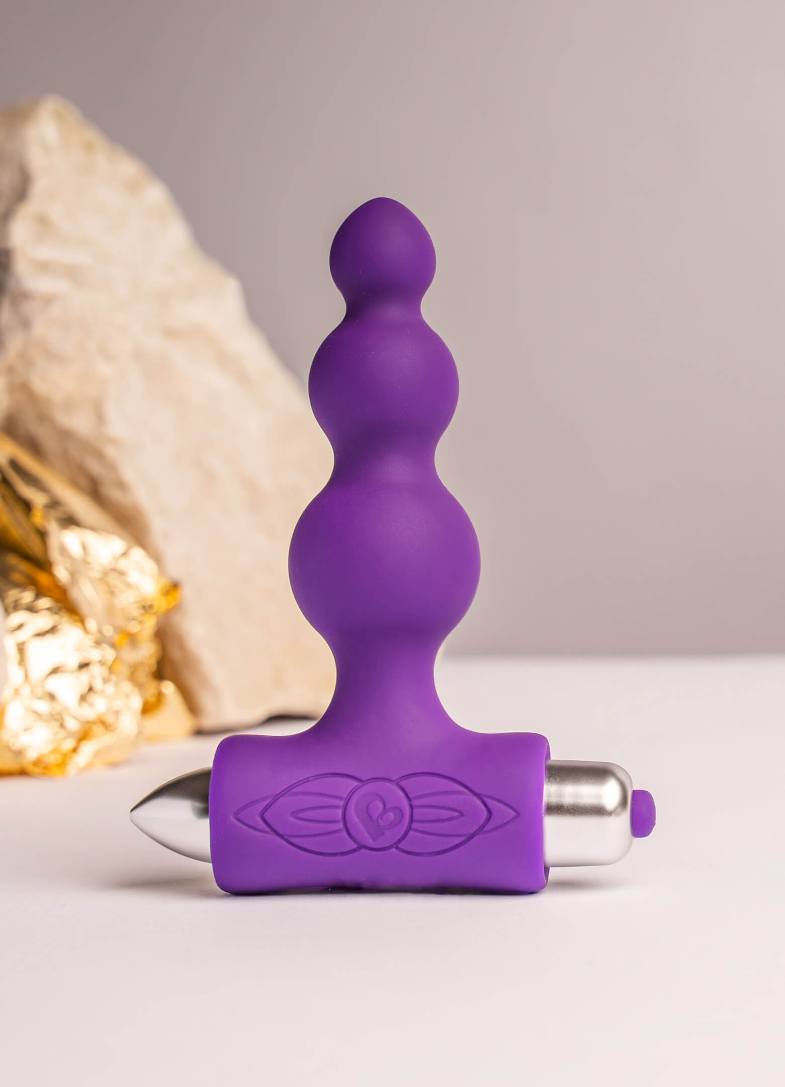 Bubbled silicone butt plug in purple housing a removable bullet vibrator.