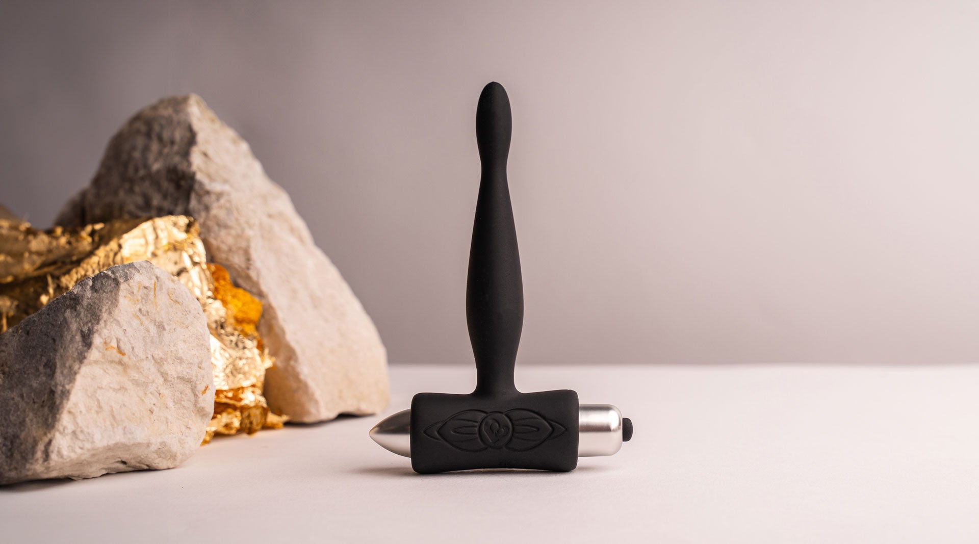 Super slim tipped silicone butt plug in black housing a removable bullet vibrator.