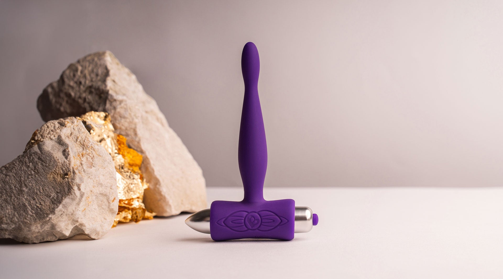 Super slim tipped silicone butt plug in purple housing a removable bullet vibrator.