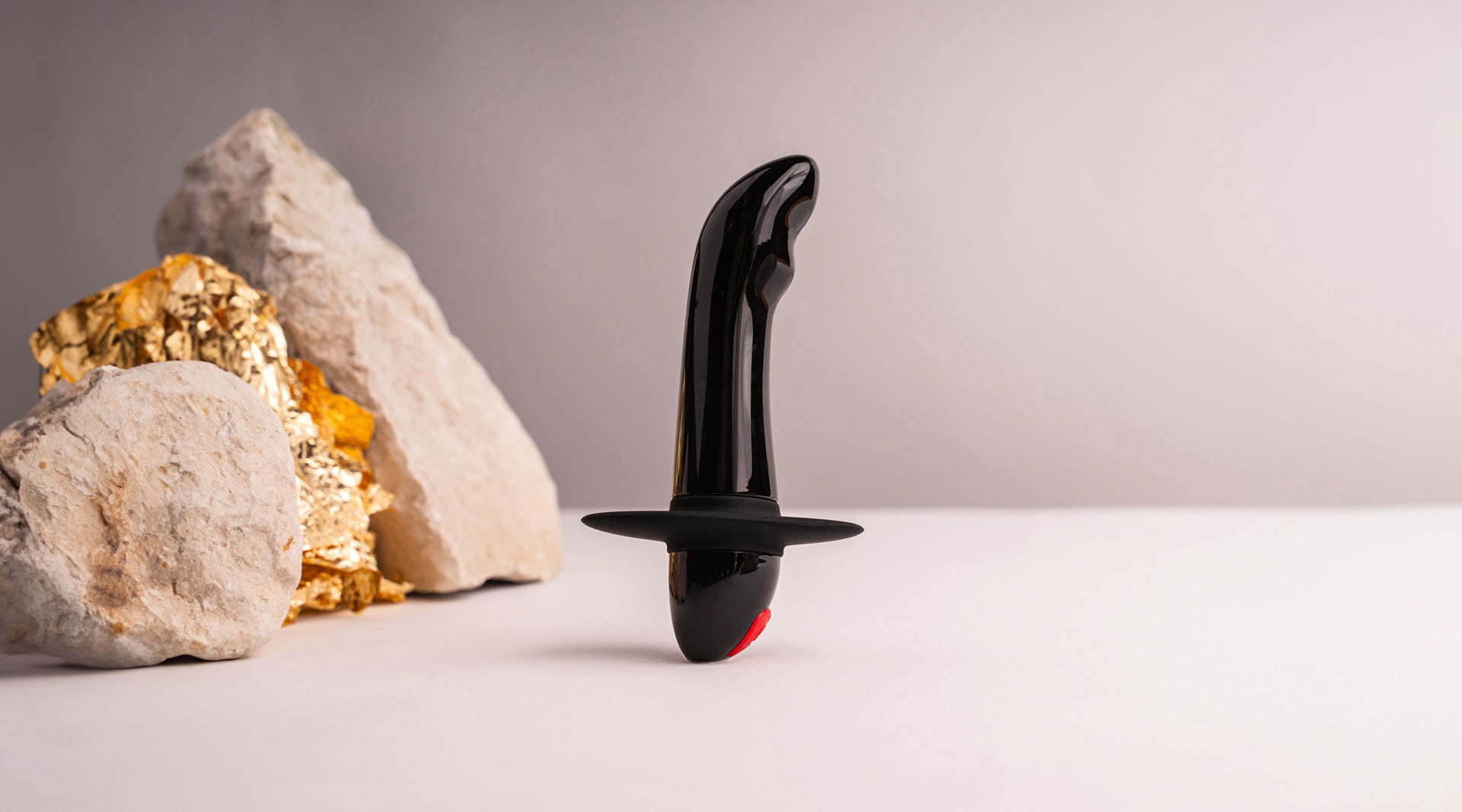 Small black prostate vibrator with a safety flange.