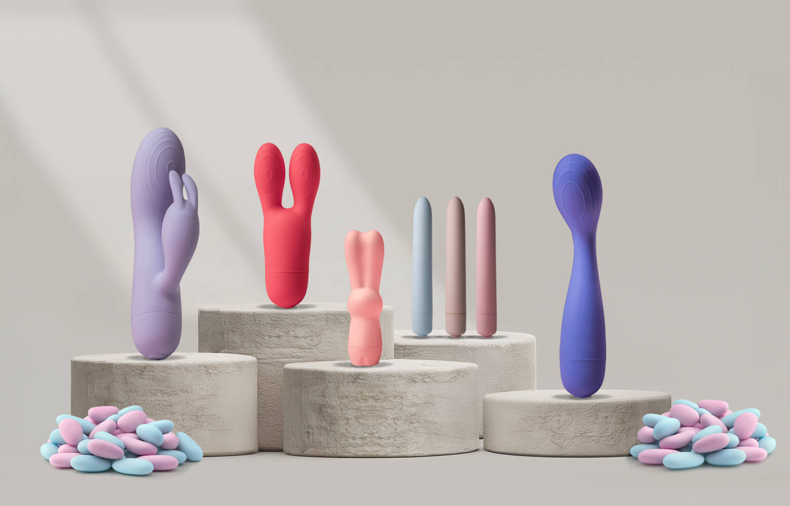 Collection of sugarboo products on a stone podium including slimline bullets, rabbit and g-spot vibrator