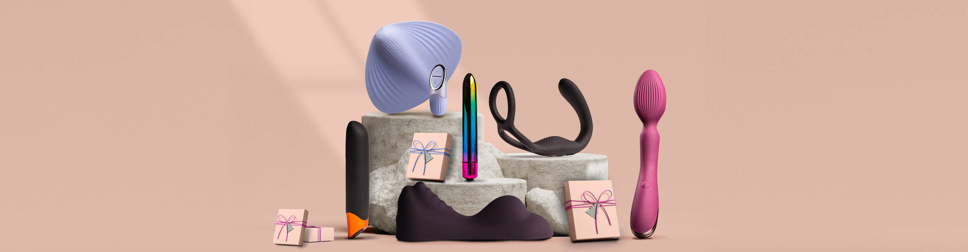 Collection of products including Sit on vibrators, Bullets and C-Rings on a grey podium surrounded by presents