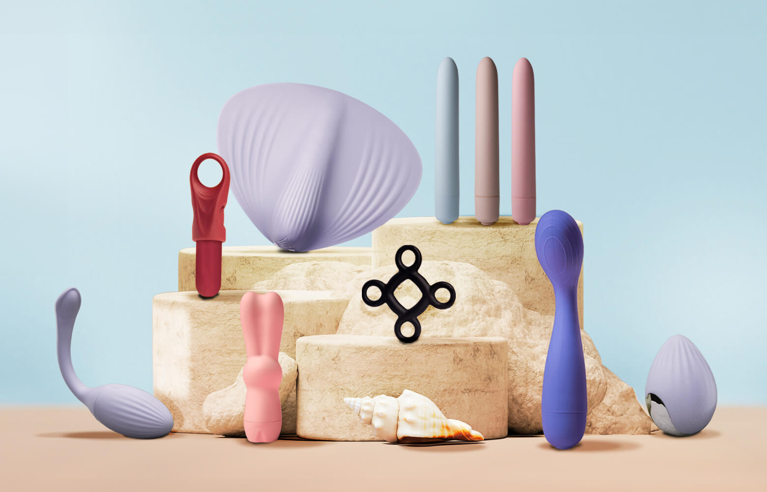 Collection of sex toys including bullets and vibrators on a sandy podium with seashells on a blue background