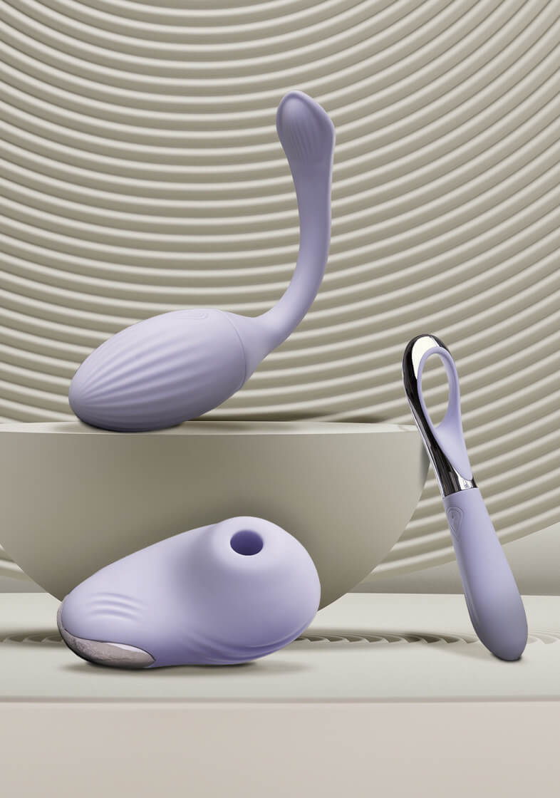 Featured collection of Niya Products set against calming sand circles including intimate massager, kegal, clit stilmulator