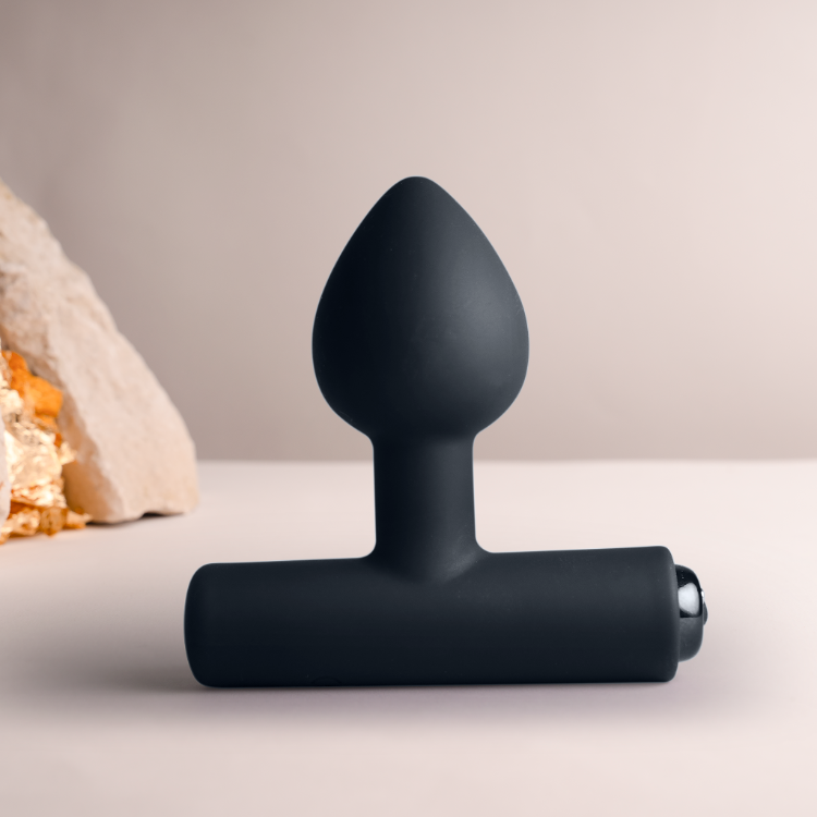 Black silicone plug standing upright, tapered tip with flared base and side port