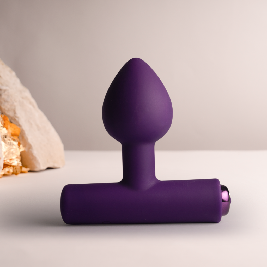 Purple silicone plug with tapered tip and flared base, side charging port